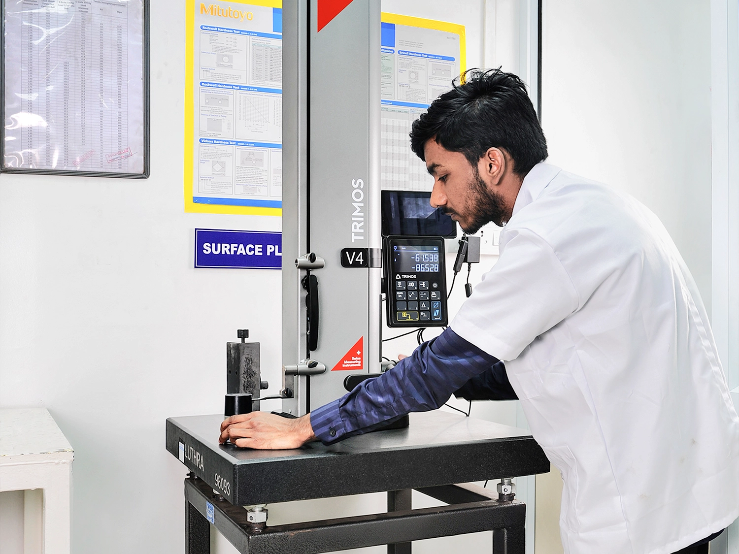Engineer measuring a component with a height gauge on a surface plate