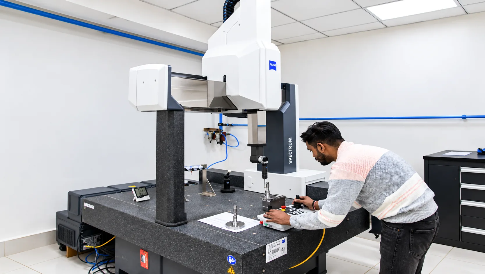 Engineer inspecting a shaft on a Zeiss coordinate measuring machine