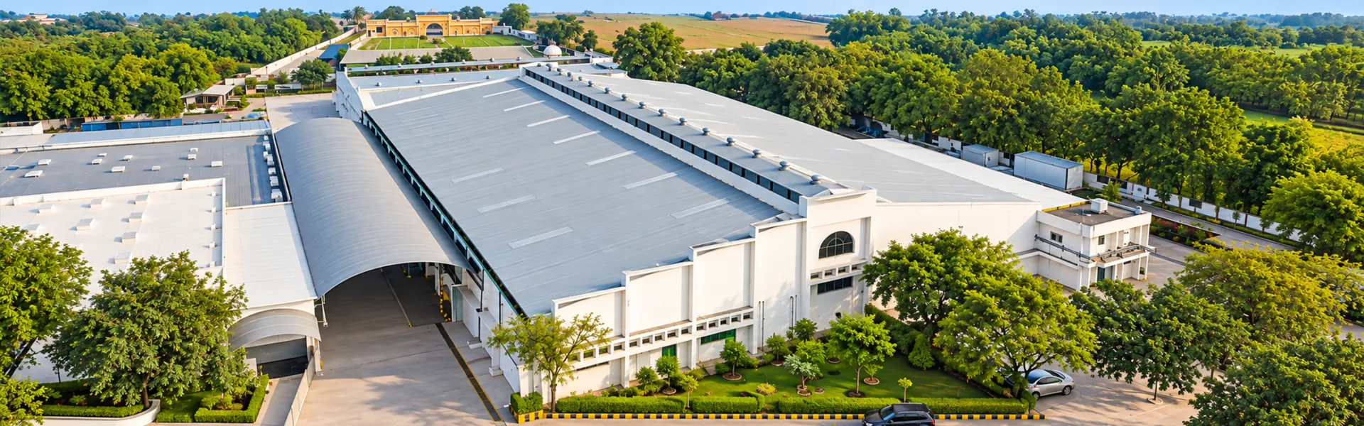 Aerial view of a Highway Roop manufacturing plant surrounded by trees